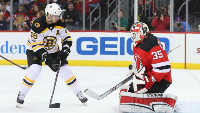 Boston Bruins center David Krejci and New Jersey Devils goaltender Cory Schneider