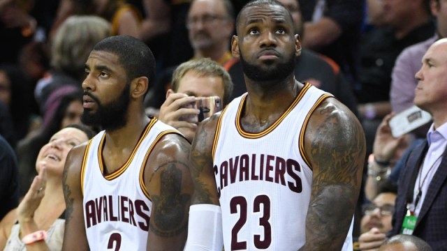Kyrie Irving sits next to LeBron James