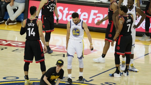 Golden State Warriors guard Stephen Curry and Toronto Raptors players