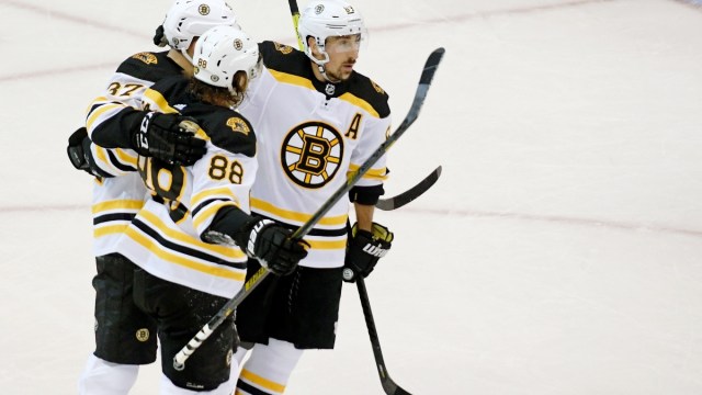 Boston Bruins left wing Brad Marchand (left), right wing David Pastrnak (left) and center Patrice Bergeron (left)