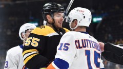Boston Bruins defenseman Jeremy Lauzon (55) and New York Islanders right wing Cal Clutterbuck (15)