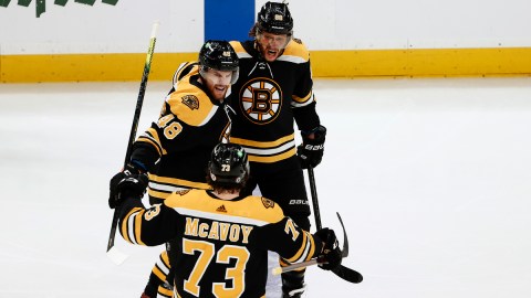 Boston Bruins defensemen Charlie McAvoy, Matt Grzelcyk and forward David Pastrnak