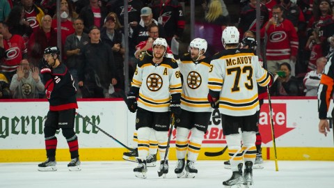 Boston Bruins right wing David Pastrnak (88), right wing Craig Smith (12) and defenseman Charlie McAvoy celebrate a late goal vs. the Carolina Hurricanes