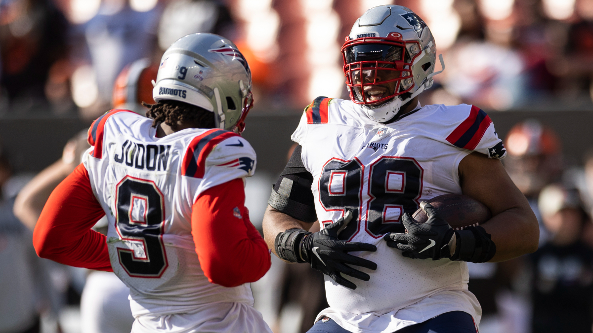 Tampa Bay Buccaneers quarterback Tom Brady (12) tosses the ball after being  taken down by New England Patriots nose tackle Davon Godchaux, right,  during the second half of an NFL football game