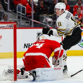 Boston Bruins forward Trent Frederic and Detroit Red Wings goaltender Alex Lyon