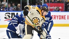 Boston Bruins forward Brad Marchand and Toronto Maple Leafs goaltender Joseph Woll and defenseman William Lagesson