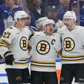 Boston Bruins defenseman Hampus Lindholm and forwards Brad Marchand and Charlie Coyle