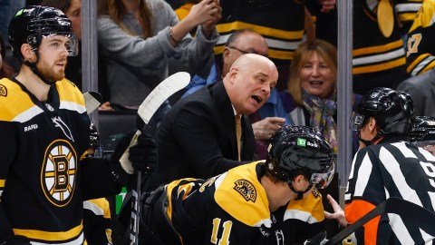 Boston Bruins head coach Jim Montgomery and forwards Johnny Beecher and Trent Frederic