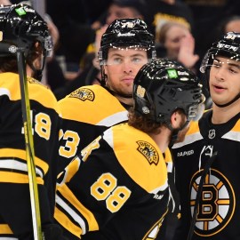 Boston Bruins forwards Pavel Zacha, David Pastrnak and Matthew Poitras and defenseman Charlie McAvoy