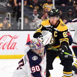 Boston Bruins forward Brad Marchand and Columbus Blue Jackets goalie Elvis Merzlikins