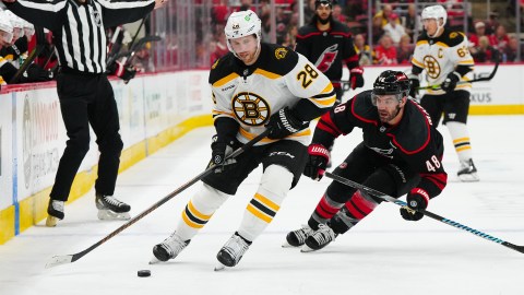 Boston Bruins forward Elias Lindholm and Carolina Hurricanes forward Jordan Martinhook