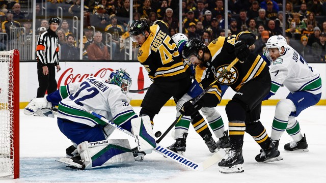 Boston Bruins forward Mark Kastelic and Vancouver Canucks goalie Kevin Lankinen