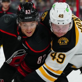 Boston Bruins forward Max Jones and Carolina Hurricanes forward Jesperi Kotkaniemi