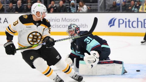 Boston Bruins forward Brad Marchand and Seattle Kraken goaltender Philipp Grabauer