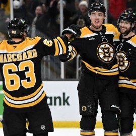 Boston Bruins forwards Brad Marchand and Pavel Zacha and defenseman Nikita Zadorov