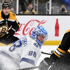 Boston Bruins forwards Trent Frederic and Matthew Poitras and Tampa Bay Lightning goaltender Andrei Vasilevskiy